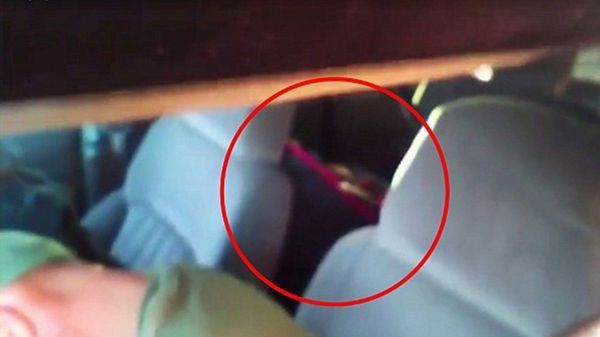 Detrás de los padres puede verse al bebé de cinco meses.